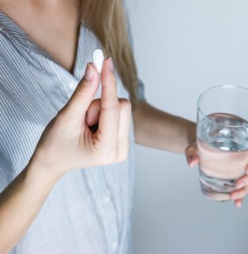 Antiphospholipid-Syndrom Behandlung und Therapie - Frau mit Glas Wasser und Tablette